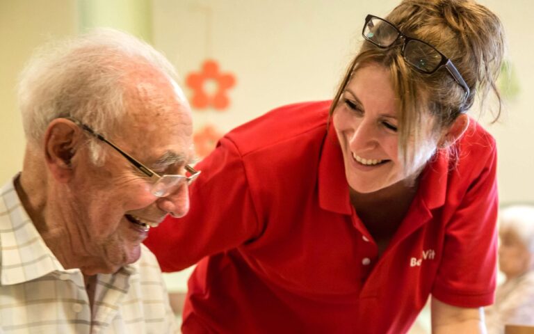 BeneVit Mitarbeiterin und Bewohner lachen gemeinsam