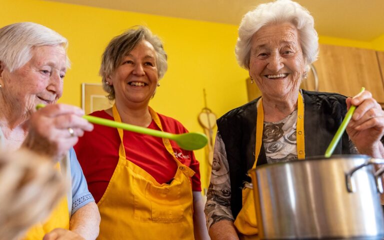 BeneVit Mitarbeiterin kocht mit zwei Bewohnerinnen
