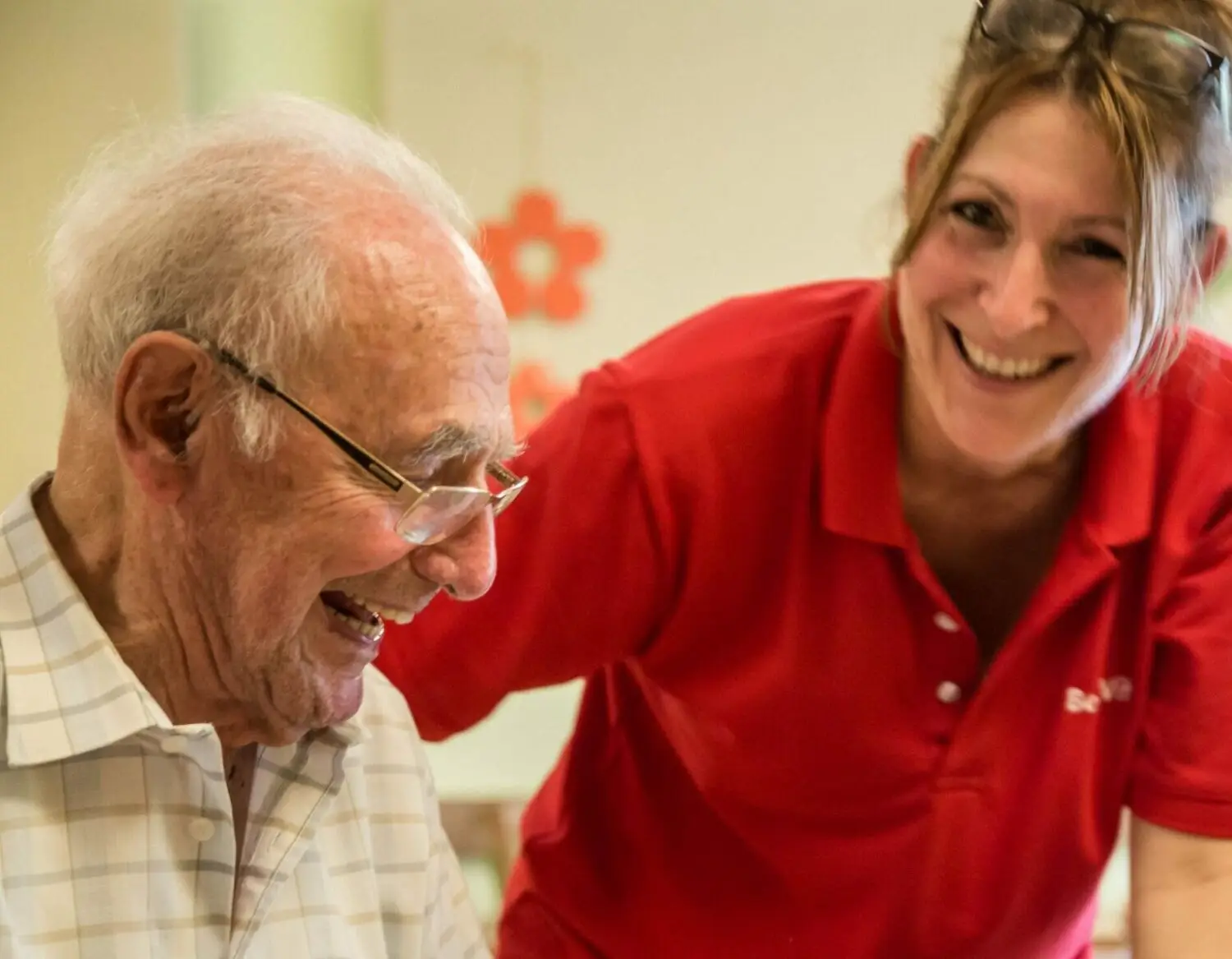 BeneVit Mitarbeiterin lacht mit BeneVit Bewohner