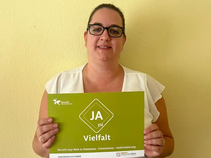 BeneVit Mitarbeiterin mit Plakat zu Vielfalt