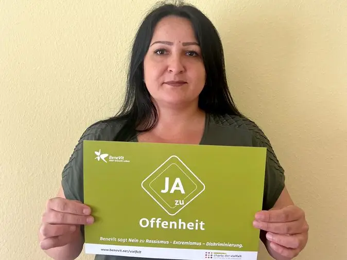 BeneVit Mitarbeiterin mit Plakat zu Offenheit