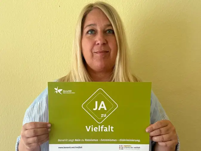 BeneVit Mitarbeiterin mit Plakat zu Vielfalt