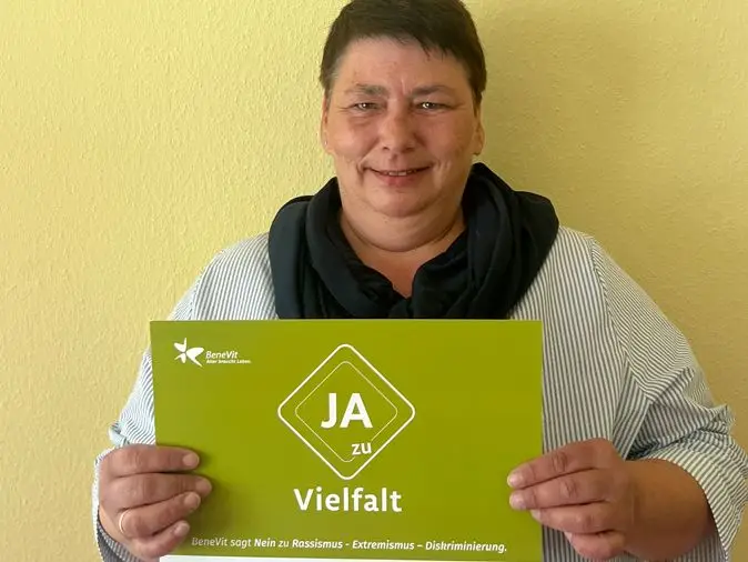 BeneVit Mitarbeiterin mit Plakat zu Vielfalt