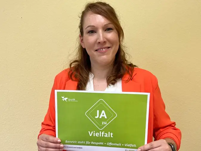 BeneVit Mitarbeiterin mit Plakat zu Vielfalt