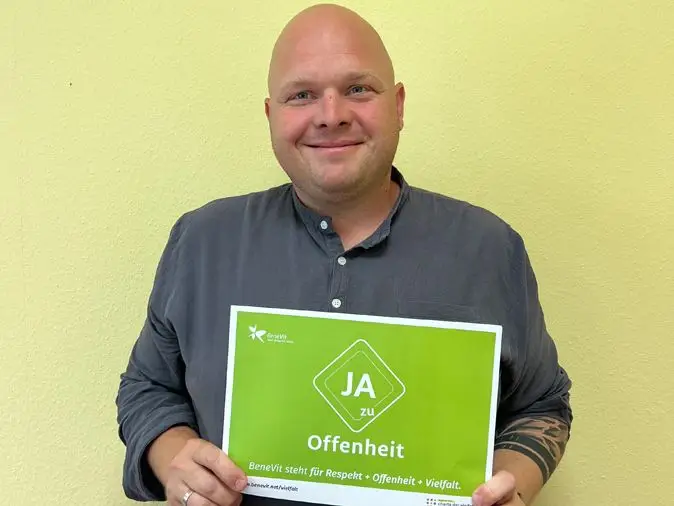 BeneVit Mitarbeiter mit Plakat zu Offenheit