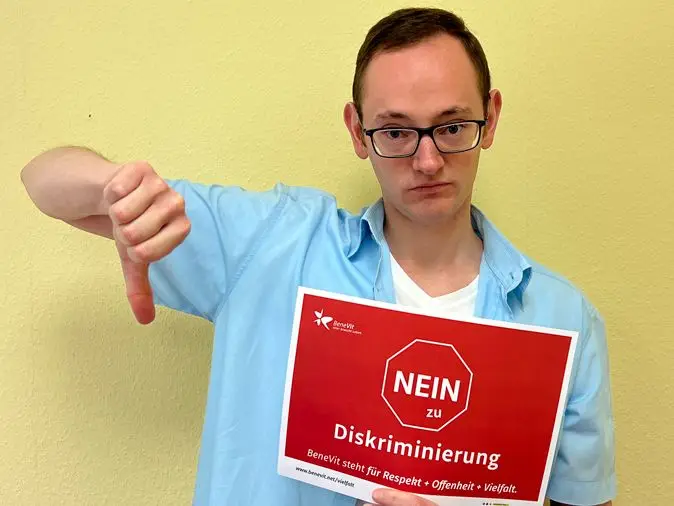BeneVit Mitarbeiter mit Plakat gegen Diskriminierung