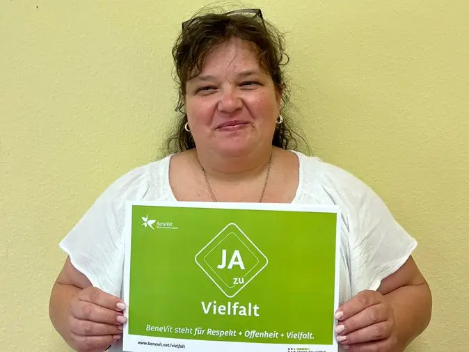 BeneVit Mitarbeiterin mit Plakat zu Vielfalt