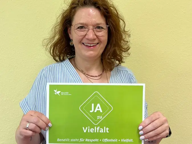 BeneVit Mitarbeiterin mit Plakat zu Vielfalt