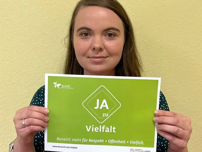 BeneVit Mitarbeiterin mit Plakat zu Vielfalt