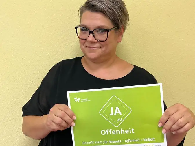 BeneVit Mitarbeiterin mit Plakat zu Offenheit