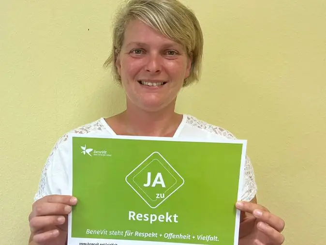 BeneVit Mitarbeiterin mit Plakat für Respekt