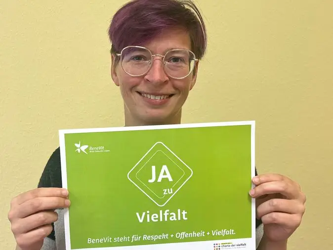 BeneVit Mitarbeiterin mit Plakat zu Vielfalt