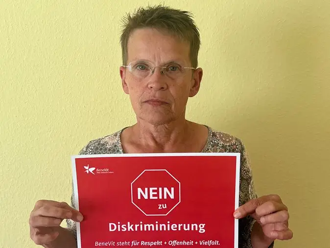 BeneVit Mitarbeiter mit Plakat gegen Diskriminierung