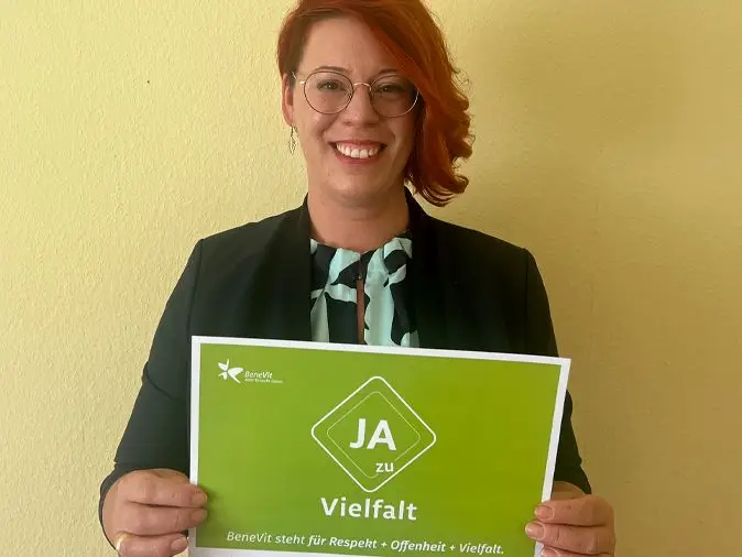 BeneVit Mitarbeiterin mit Plakat zu Vielfalt