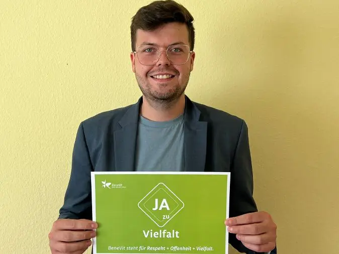BeneVit Mitarbeiter mit Plakat zu Vielfalt